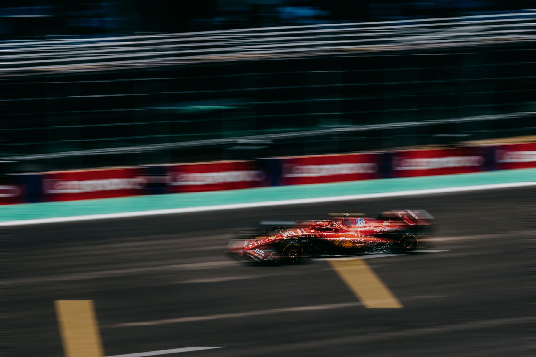 A red racecar blurred as it speeds along a track