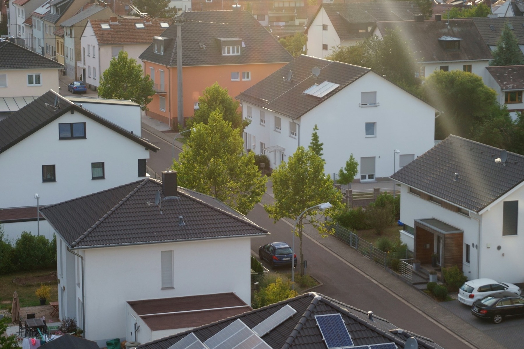 An aerial view of a residential neighborhood with solar panels on several rooftops